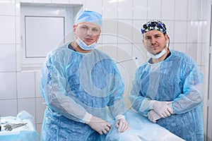 A team of doctors in the operating room conducts medical procedures. Surgeons in sterile clothing work in the hospital