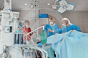 A team of doctors performs an operation. A group of surgeons at work in the operating room, saving the life of the