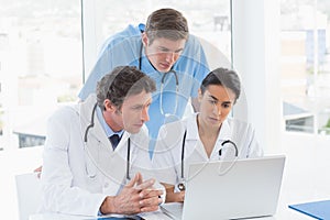 Team of doctors working on laptop computer