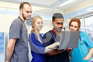 Multiracial team of young doctors working on laptop computer in medical office.