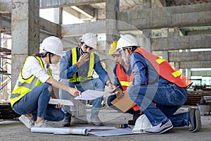 Team of engineer, architect, contractor and foreman meeting and consulting at construction building site with floor plan for real