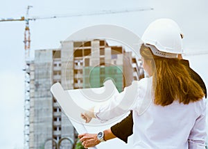 Team of engineer building construction working together. Engineer checking progress of construction in blueprint