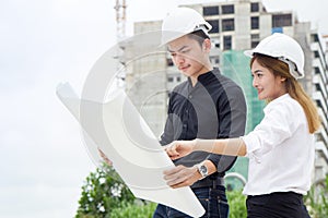 Team of engineer building construction working together. Engineer checking progress of construction in blueprint