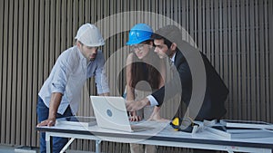 Team engineer discussion and examining panel solar cell with system laptop computer.