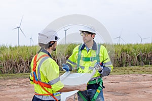 Team engineer wearing safety uniform discussed plan working on wind turbine renewable energy power wind. technology protect