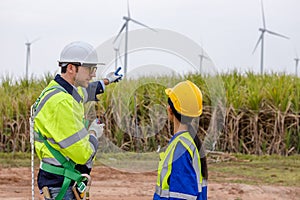 Team engineer of wind turbine worker pointing working about renewable energy at station energy power wind. technology protect