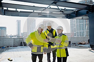 Team of engineers and construction workers inspecting building progress.