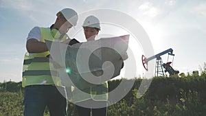 Team engineers discussing the maintenance of a oil pump field. Engineering team working in Oil refinery. Two workers