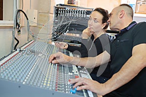 Team engineers working at mixing desk in recording studio