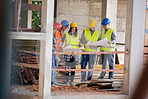 Team of experts studying blue print at construction site photo