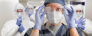 Team of Female and Male Doctors or Nurses Wearing Personal Protective Equipment In Hospital Hallway photo