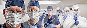 Team of Female and Male Doctors or Nurses Wearing Personal Protective Equiment In Hospital Hallway