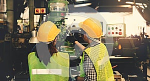 Team of female mechanics working in a lathe inspects the drill stand and put on safety gear.