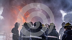 Team of fire fighters was trained to extinguishing huge flame with water hydrant photo