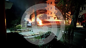 Team of firefighters extinguishes a car burning in a residential area