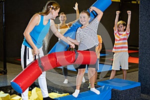 Team of friends playing with inflatable sticks in amusement park