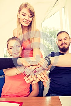 Team of friends showing unity with their hands together