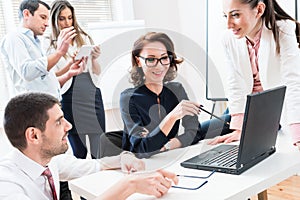 Team giving business report to boss in office photo