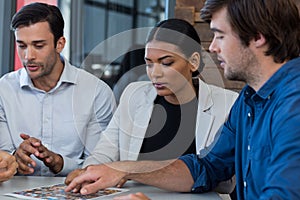 Team of graphic designers discussing over photos