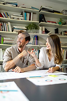 Team of happy successful architects working on construction plans in office.