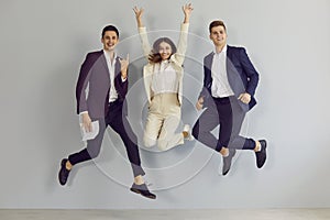 Team of three happy young business people jumping and having fun at office party