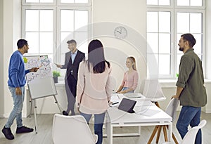 Team of happy young business people having a meeting in their office with a whiteboard