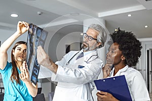 Team of healthcare professionals looking x-ray of the patient`s lungs. Male and female doctor looking at lungs x-ray in hospital