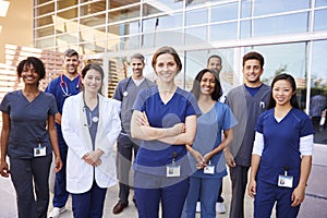 Team of healthcare workers with ID badges outside hospital