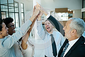 When the team hits a homerun, everyone cheers and high-fives. a group of colleagues giving each other a high five. photo