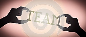 Team - human hands holding black silhouette word