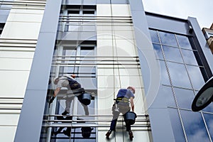 Team of industrial climbers at work, they are washing building f