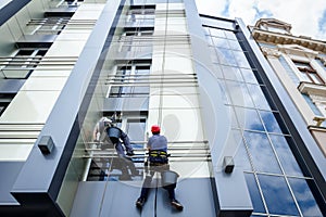 Team of industrial climbers at work, they are washing building f