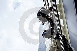 Team of industrial climbers at work, they are washing building f