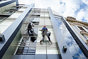 Team of industrial climbers at work, they are washing building f