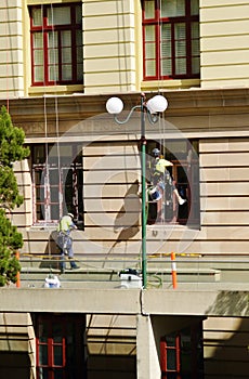 Team of industrial painters in safety gear painting old office building
