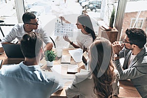 Team of innovators. Top view of young modern people in smart casual wear discussing business while working in the creative office