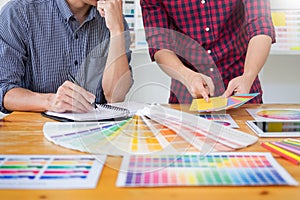 Team interior designer drawing a new project using graphic computer and choosing Color swatch samples in modern Creative studio