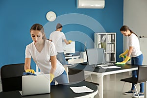 Team of janitors cleaning office