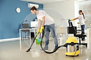 Team of janitors cleaning office