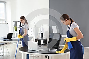 Team of janitors cleaning office