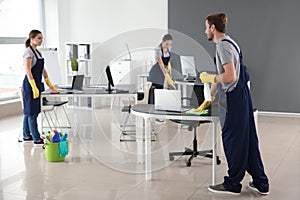 Team of janitors cleaning office