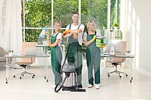 Team of janitors with cleaning supplies photo