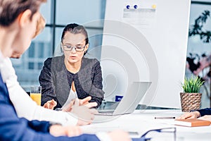 Team leader and business owner leading informal in-house business meeting