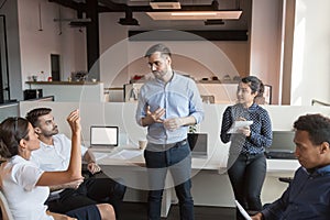 Team leader discuss work issues with colleagues at informal briefing