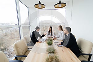 Team listen at meeting leader of project at conference table.