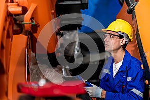 A team of male and female engineers meeting to inspect computer-controlled steel welding robots. Plan for rehearsals and