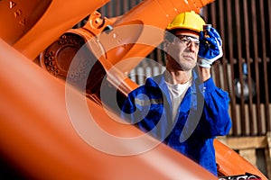 A team of male and female engineers meeting to inspect computer-controlled steel welding robots. Plan for rehearsals and