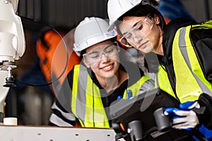 A team of male and female engineers meeting to inspect computer-controlled steel welding robots. Plan for rehearsals and