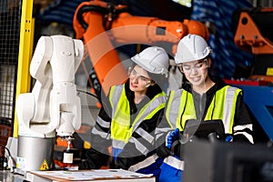 A team of male and female engineers meeting to inspect computer-controlled steel welding robots. Plan for rehearsals and