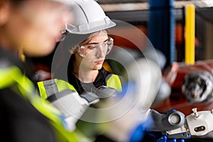 A team of male and female engineers meeting to inspect computer-controlled steel welding robots. Plan for rehearsals and